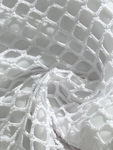 Close-up of white crochet mesh fabric with diamond patterns and soft inner lining