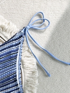 Detail of striped woven bikini bottom featuring texture and light blue tassel side ties