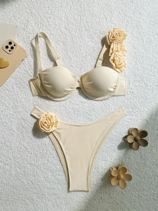 Detailed flat lay of beige push-up bikini set with elegant 3D fabric rose flower accents
