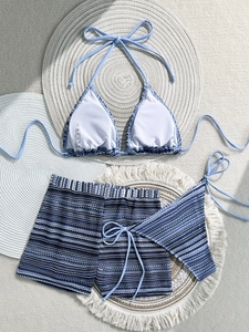 Detailed flat lay of blue and white striped 3-piece bikini set with shorts and wash label