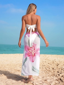 Three-piece bikini set with white tube top and floral print sarong for beach vacation