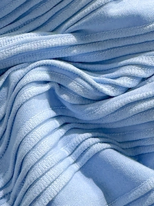 Vista macro del tessuto bikini celeste con trama a righe a conchiglia e cuciture fini