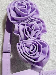 Detail of lavender swimsuit fabric with three 3D handmade fabric roses and fine stitching