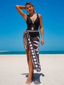 Elegant black deep V-neck swimsuit with sun-shaped gold buckle and printed beach wrap