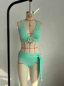 Détail du bikini vert menthe avec tissu texturé, décolleté licou et ornements perlés