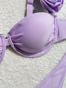Close-up of lavender bikini top featuring handcrafted fabric rose and pleated detailing