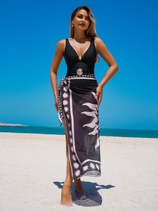 Women's black one-piece swimsuit and matching sunburst print wrap skirt set