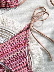 Detailed macro view of bohemian crochet knit bikini fabric with colorful striped texture