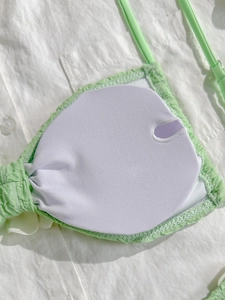Detail view of light green bikini top featuring removable pads and textured seersucker fabric