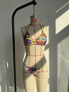 Detail of colorful checkerboard bikini fabric with evil eye print on mannequin