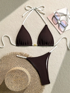 Detail of chocolate ribbed bikini set with gold shell buckle and white ties for beachwear