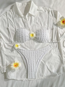Detailed view of white textured seersucker bikini set with plumeria flowers decor