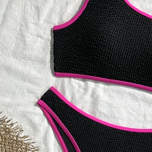 Detail of smocked popcorn texture on black and pink contrast two-piece bikini set