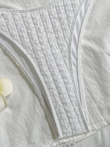 Macro detail of white seersucker bikini fabric with vertical textured stripe pattern