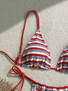 Detail of red and blue striped bikini with textured fabric and red string ties