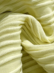 Dettaglio macro del tessuto bikini verde-giallo con pieghe 3D strutturate