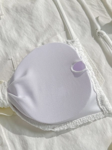 Detail of white bikini lining featuring breathable mesh and removable padding slot