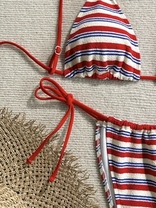Detail view of striped bikini set with textured seersucker fabric and red ties