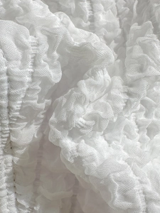 Detailed close-up showing the textured seersucker fabric of the white bikini swimwear