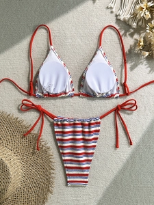 Close-up of striped bikini top with removable pads and beach lifestyle props