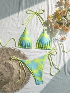 Flachbild des Batik-Bikinis mit seitlich gebundenen Hosen und Sommerferien-Accessoires