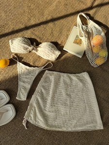 Three-piece off-white bikini set with starfish charms and matching sarong in textured fabric