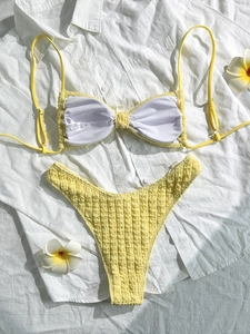 Bright yellow textured two-piece bikini set with bow design and tropical frangipani