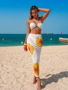 Detail of white halter bikini top with yellow flower 3D ornament and matching beach skirt