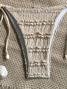 Close-up of smocked bikini bottoms with ruffled edges and seashell drawstring details