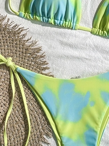 Flachbild-Set des Batik-Bikinis mit seitlich gebundener Hose auf Strohmatte