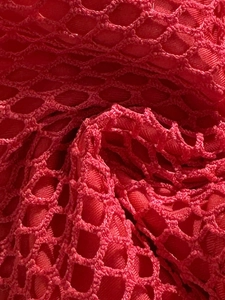 Macro shot of red mesh fabric showing honeycomb texture and woven polyester details