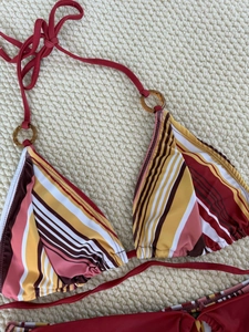 Women's halter bikini top with multicolor stripes and decorative amber rings on the straps