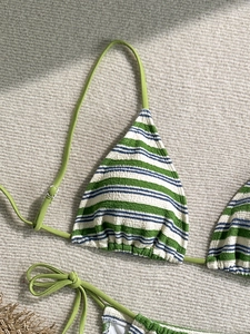 Detail of striped textured fabric bikini with adjustable green halter neck ties and metal buckles