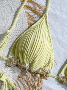Detail of yellow ribbed bikini top with woven lace hem and real seashell charms