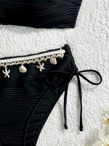 Bikini a coste nero con bordo in pizzo bianco e ciondoli a conchiglia per la spiaggia