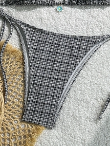 Sexy black and white checkered bikini bottom with side ties and blue daisy pendant