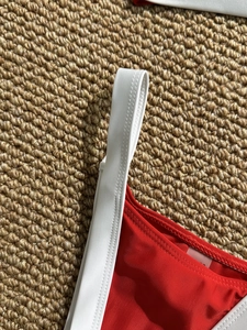 Women's two-tone red and white bikini top detail featuring high-elastic fabric and flat seams