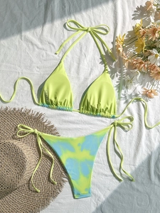 Nahaufnahme des neongrünen Bikinioberteils mit Batik-Paspel und Waschetikett in Größe S