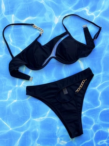 Detaillierte Flachbildansicht des schwarzen Bikinis mit Cut-Outs und goldenen Ketten auf Blau