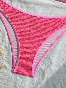 Close-up of rose pink high-cut bikini bottoms in textured crinkle seersucker fabric
