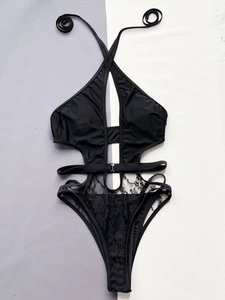 Detail of black V-neck cutout swimsuit featuring halter neck with rings and lace fabric