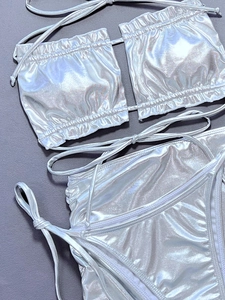 Flat lay detail of silver metallic bikini set with pleated texture and side tie strings