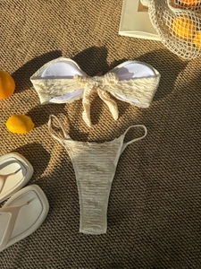 Three-piece solid color crinkle bikini set with bow tie detail and beach accessories