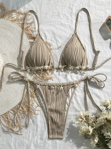 Detail of beige ribbed bikini featuring crochet lace trim and seashell starfish charms