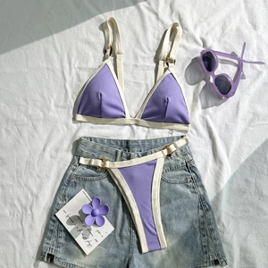 Detailansicht des lila gerippten Bikinisets mit Tigerprint-Ringen und Denim-Shorts