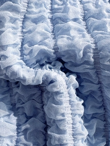 Detail of light blue smocked mesh fabric texture for solid bikini swimwear design