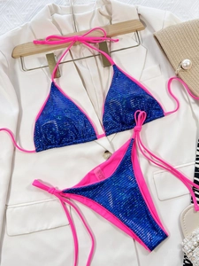 Dettaglio bikini con paillettes blu, lacci rosa e accessori per le vacanze