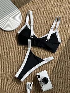 Flat lay of black and white contrast bikini with V-neck top and high cut bottoms