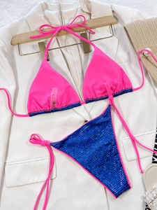 Dettaglio del bikini con paillettes rosa e blu che mostra l'etichetta e la taglia S