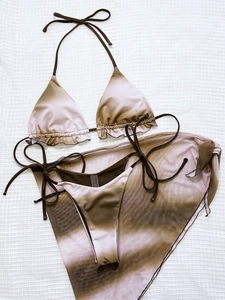 Detailed flat lay of a 3-piece ombre bikini set with ruffled edges and mesh sarong